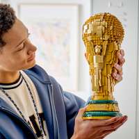 Ein Mann hält einen WM Pokal aus Legosteinen in der Hand