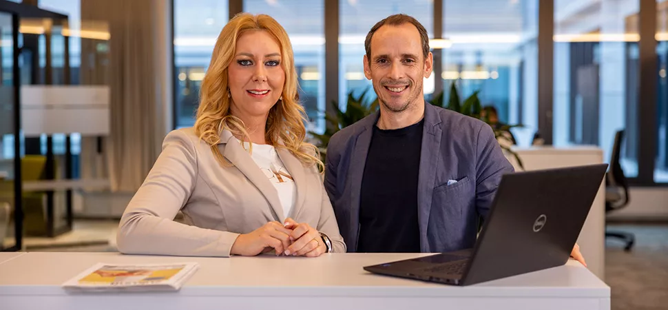 Eine Frau und ein Mann von der Sparkasse blicken professionell in die Kamera