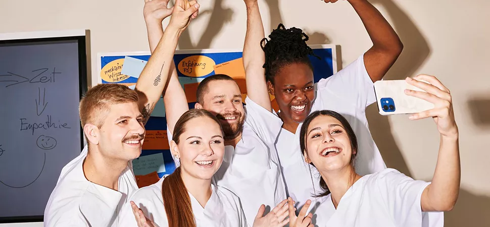 Eine Gruppe junger Leute aus dem Medizin Sektor macht ein Selfie