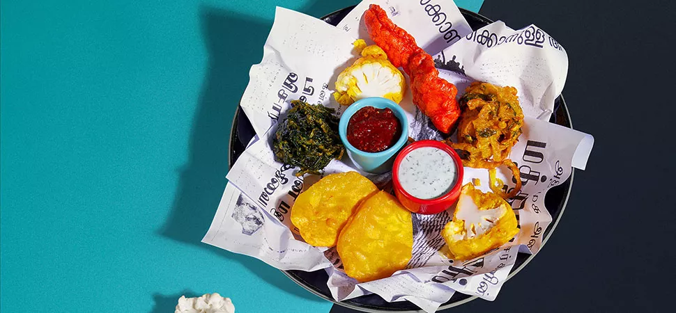 Foto von einem Teller Pakora und Soßen von oben