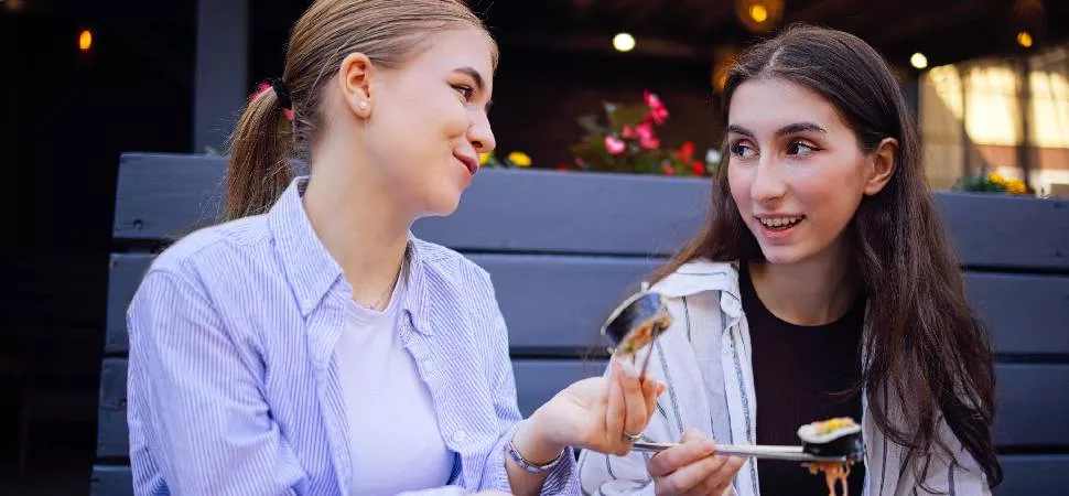 Zwei Girls die zusammen Sushi essen