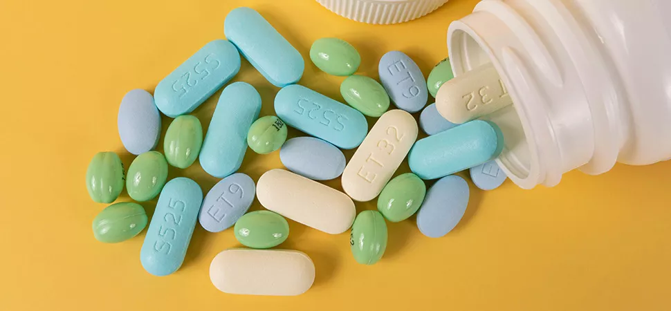 Vitamine und Nahrungsergänzungsmittel Vitaminpillen und Nahrungsergänzungsmittel werden aus einer Dose geschüttet