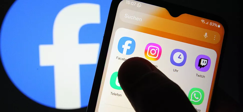 Auf einem Smartphone sind verschiedene Apps zu sehen - darunter Facebook. Dahinter wurde auf einem Smartphone das Facebook-Logo geöffnet. 