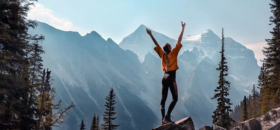 Frau steht auf einem Berg in Kanada.