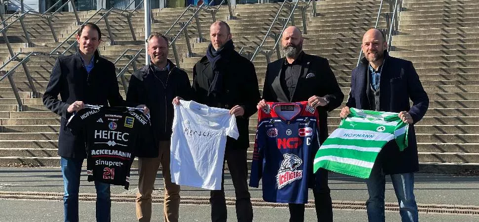 fünf Männer mit Vereinstrikots in der Hand vor der Arena Nürnberger Versicherungen