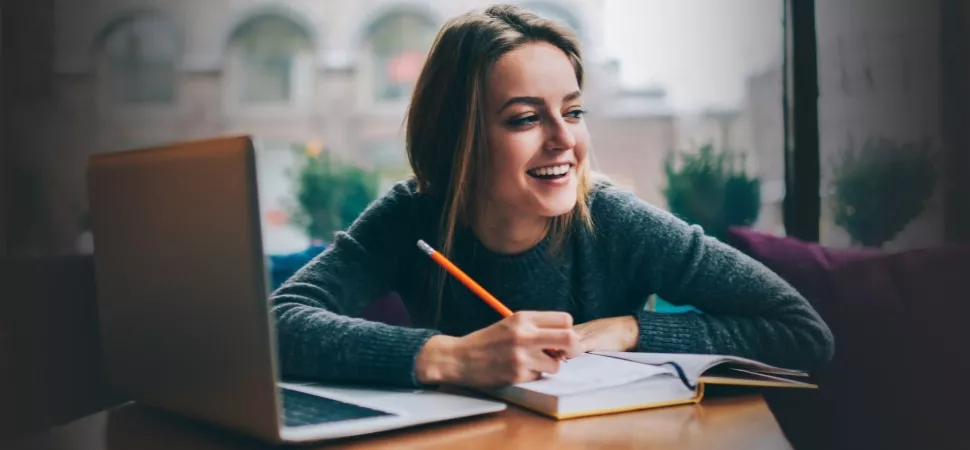 Kostenlose Programme für deine Hausarbeit Laptop mit Studentin, die lacht