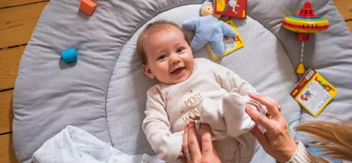 Baby auf Krabbeldecke