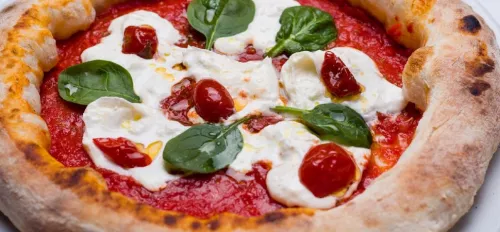 Pizza mit Käse, Tomaten und Basilikum