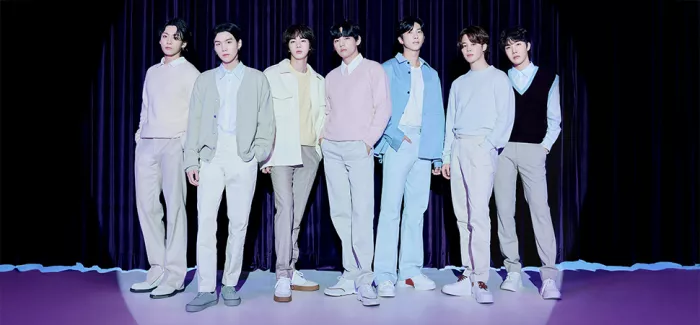 BTS Bandmitglieder stehen vor einem Vorhang
