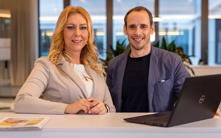 Eine Frau und ein Mann von der Sparkasse blicken professionell in die Kamera