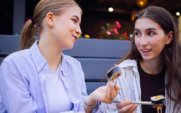 Zwei Girls die zusammen Sushi essen