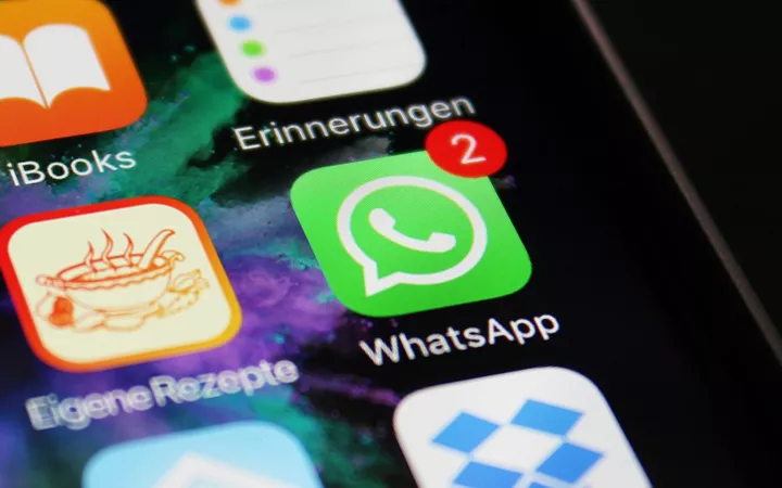 WhatApp App Icon mit 2 Mitteilungen zwischen anderen App Icons