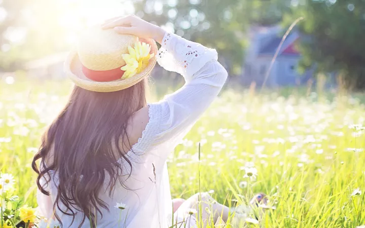 Frau genießt Sonnenstrahlen auf Blumenwiese Frau genießt Sonnenstrahlen auf Blumenwiese
