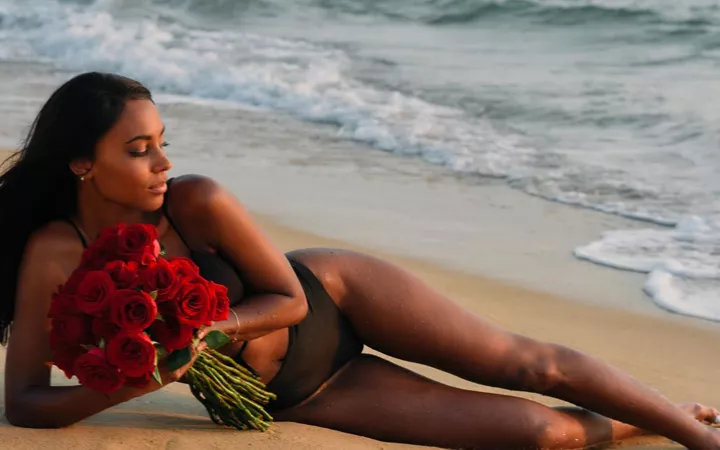 Bachelorette liegt mit Rosen am Strand