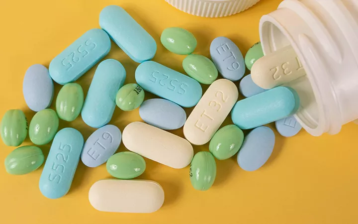 Vitamine und Nahrungsergänzungsmittel Vitaminpillen und Nahrungsergänzungsmittel werden aus einer Dose geschüttet