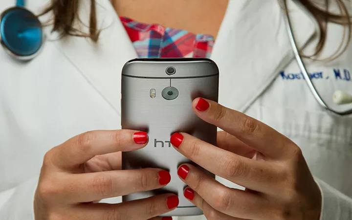 Doktorin hält ein Handy in der Hand