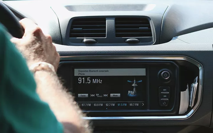 Ein Auto von innen mit Fahrer, Blick aufs Autoradio
