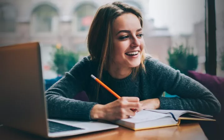 Kostenlose Programme für deine Hausarbeit Laptop mit Studentin, die lacht