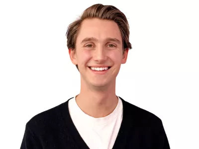 Blonder junger Mann mit weißem Shirt und schwarzem Cardigan