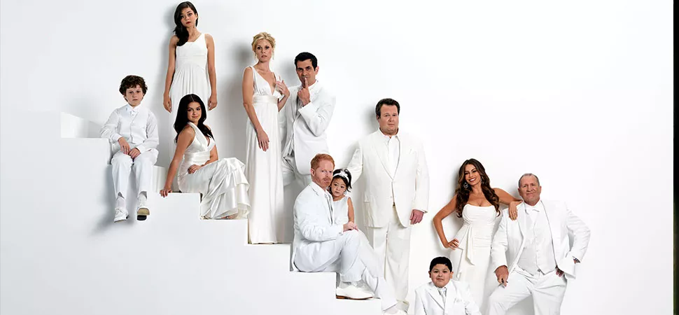 Der Cast von "Modern Family" in all-white auf einer Treppe