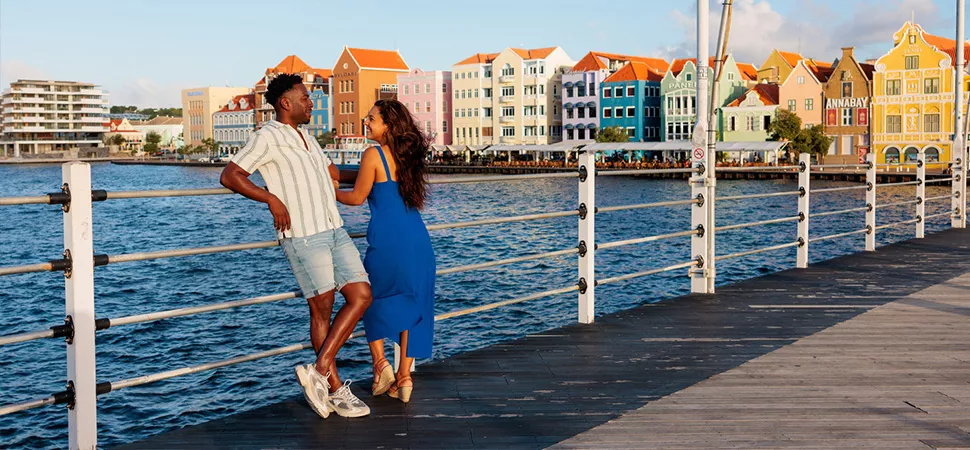 Zwei Personen auf Curacao, im Hintergrund die bunten Häuser