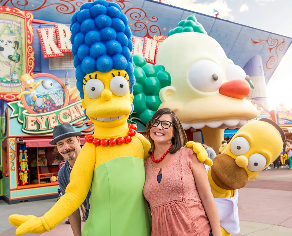 Zwei Personen posen mit Simpsons Figuren 