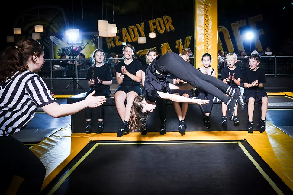 Eine Gruppe Kinder bejubelt jemanden beim Trampolinspringen