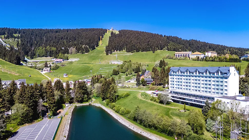 Eine Landschaft mit Bergen, einem See und einem Hotel