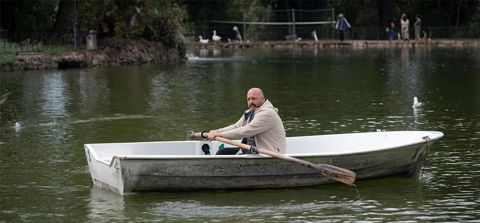 Ein Mann auf einem kleinen Ruderboot