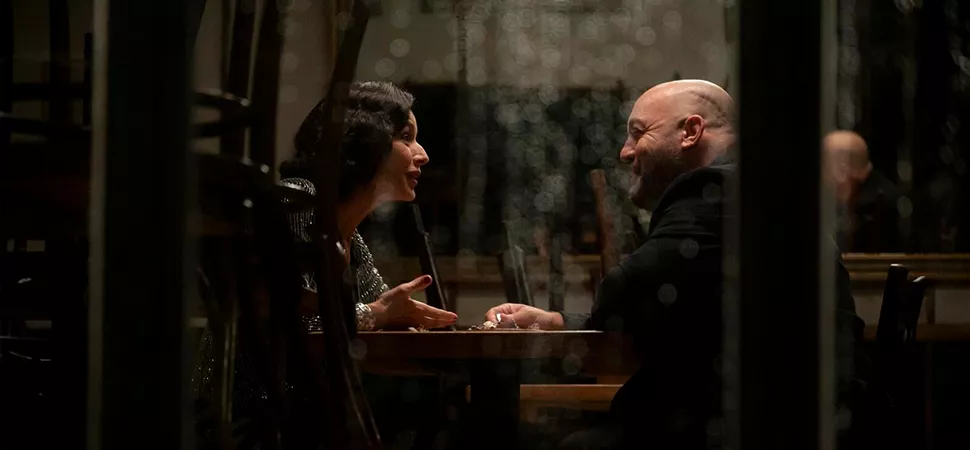 Ein Mann und eine Frau sitzen sich in einer Bar gegenüber