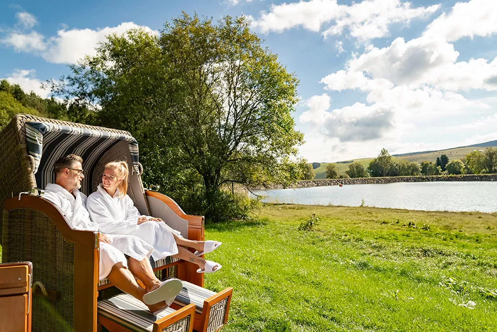 Ein Mann und eine Frau sitzen in Bademänteln in einem Strandkorb