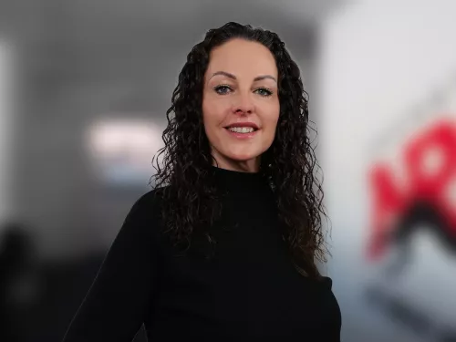 Frau mit schwarzen Locken in schwarzem Rollkragen