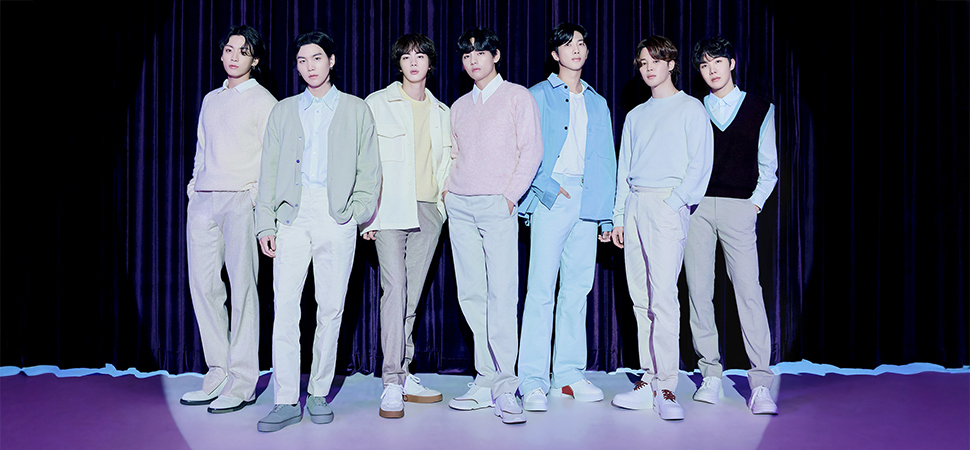 BTS Bandmitglieder stehen vor einem Vorhang