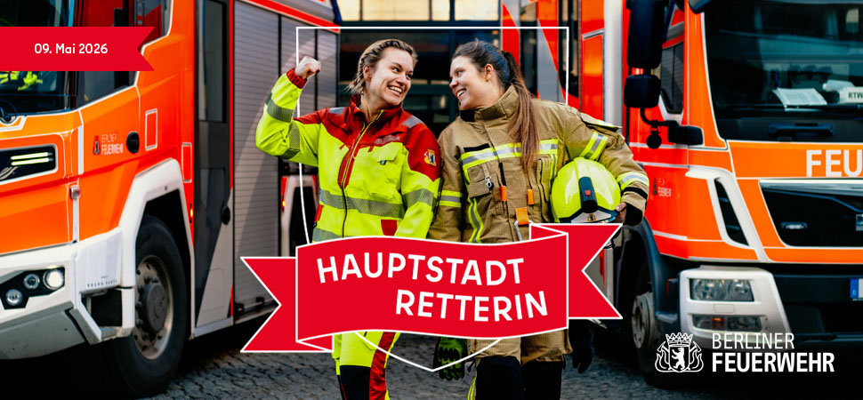 Zwei Feuerwehrfrauen neben Feuerwehrautos